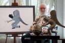 Billy Connolly sits next to his newest painting and sculpture, And On Monday, God Made the World (Castle Fine Art/PA)