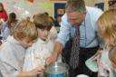 SCIENTIFIC: Stuart White helping some of the pupils with an experiment at Wool C of E First School
