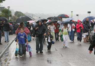Spectators make their way home during one of the torrential downpours of the day.