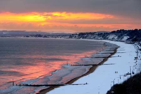 Sunset over a snow covered beach looking west from Bournemouth. Picture: Richard Crease.