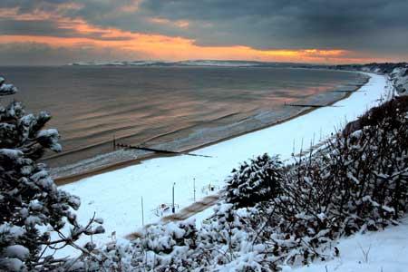 Sunset over a snow covered beach looking west from Bournemouth. Picture: Richard Crease.