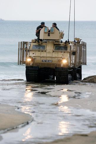 The first day of Bournemouth Air Festival sees torrential rainfall. An Army CVRT vehicle sits on a rain soaked beach.