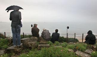 A handful of spectators wait  in vain  on the clifftop  for  any flying  on the first day of the Bournemouth Air Festival. The promised night air display  was cancelled due to the weather.