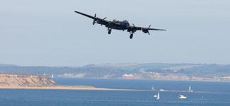 Saturday Flying display. Lancaster from the Battle of Britain memorial flight makes an approach from Hengistbury Head. 