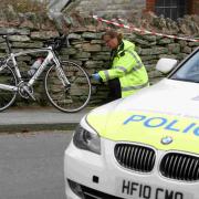 PROBE: Police examine the bike at the scene of the crash