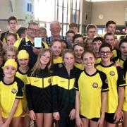 SUCCESS: Poole swimmers surround Barry Alldrick as he receives his South West Coach of the Year trophy from regional president Bob Holman