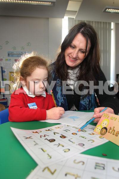  Sylvan First School in Parkstone, Early Years teacher Nikki Percy helps Kaitlin Harrison with her writing.