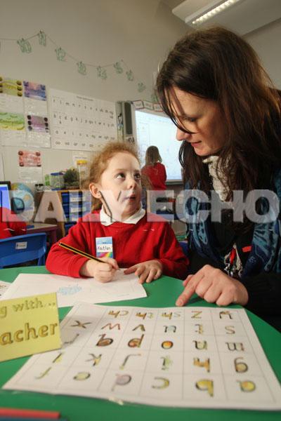  Sylvan First School in Parkstone, Early Years teacher Nikki Percy helps Kaitlin Harrison with her writing.