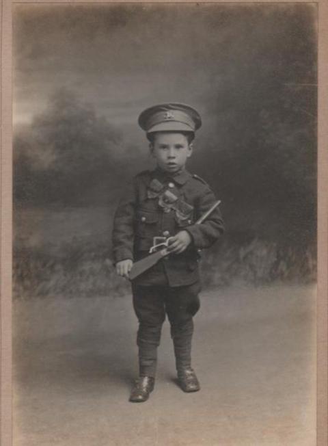 Little soldier boy, possibly dressed up to match his dad, during the First World War