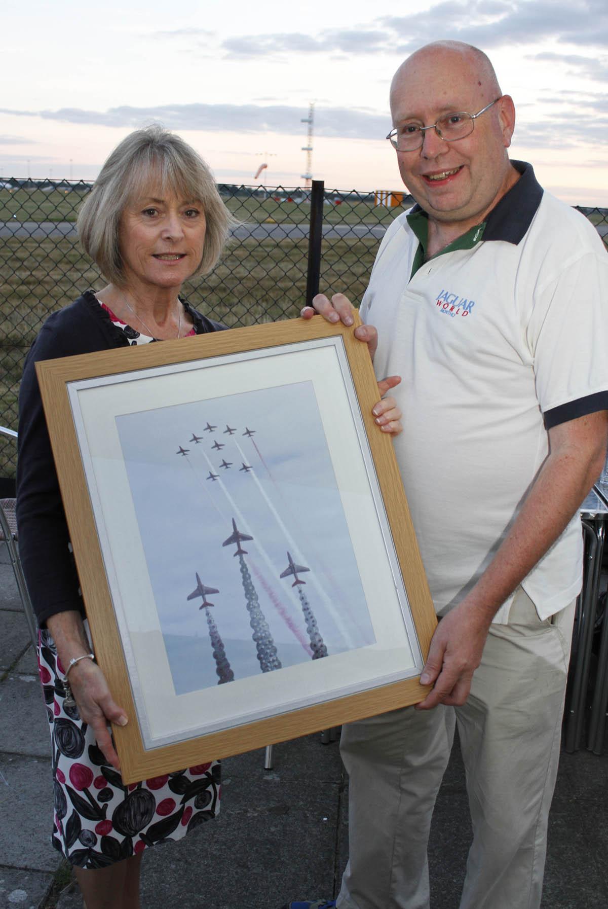 Bournemouth Red Arrows Association Barbecue at Bournemouth Flying Club ...  Stuart James with his photograph of the Red Arrows memorial with today's display in the background, and Dawn Egging from the Jon Egging Trust.