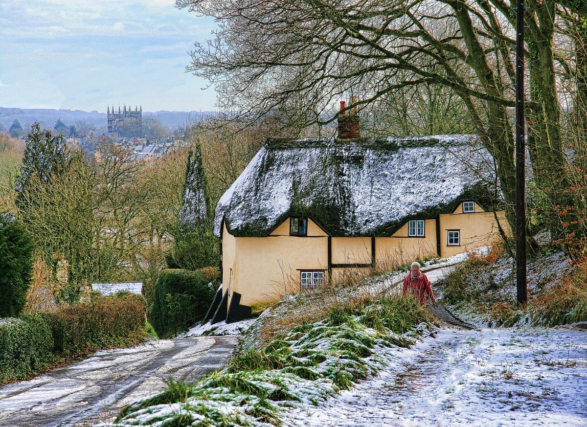 Light dusting of snow in the winter - showing one of the thatched cottages at Pamphill and tower of Wimborne Minster in the distance taken by  Kay Browning.  