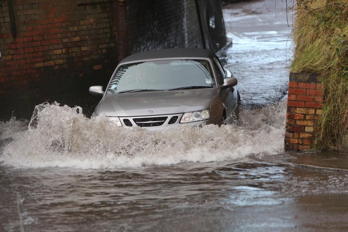 Heavy rain and strong winds cause flooding and high tides across Dorset. Motorists driving  through the flooded tunnel under the railway line in Whitecliff Road  