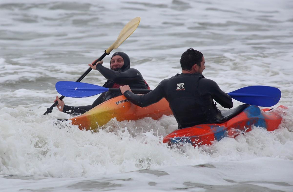 Heavy rain and strong winds cause flooding and high tides across Dorset. Kayakers enjoy the surf at Boscombe beach.