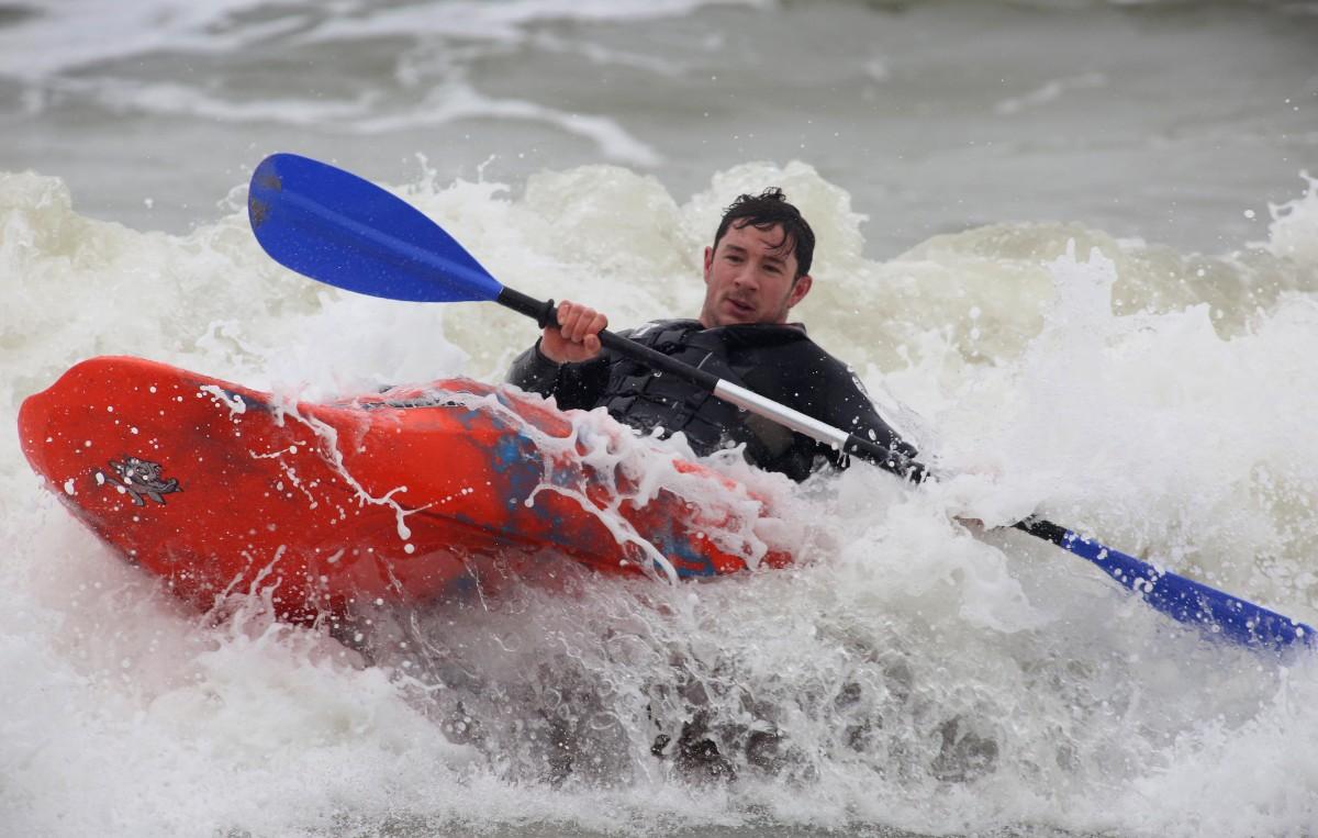Heavy rain and strong winds cause flooding and high tides across Dorset. Kayakers enjoy the surf at Boscombe beach.