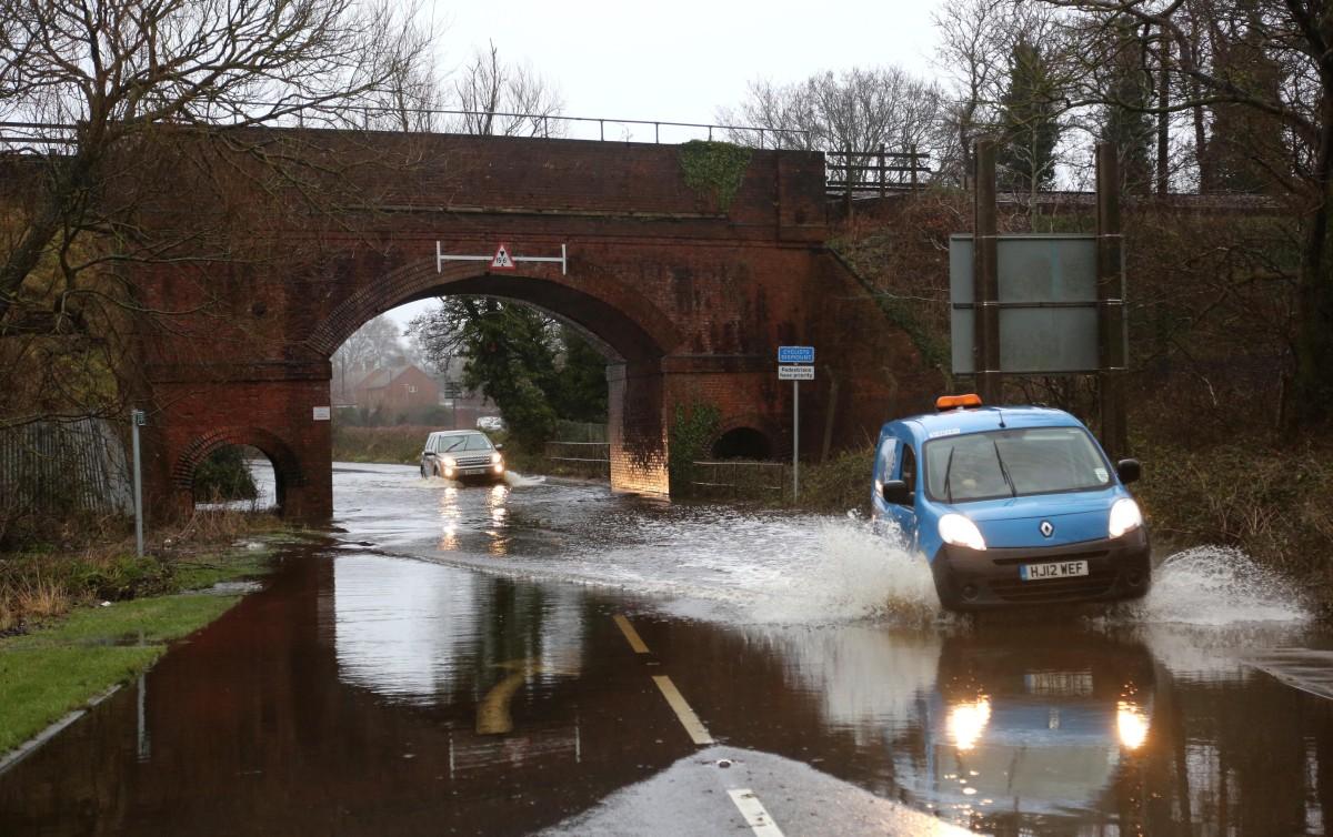Heavy rain and strong winds cause flooding and high tides across Dorset. Cars driving though the flooded Stony Lane underneath the railway bridge.