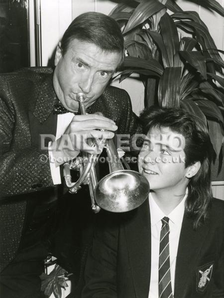 Entertainer Roy Castle was at the opening of Bournemouth's new Asda Superstore. Here he blows his own trumpet watched by Julie Bygden cornet player from Oakmead School band, 1988.