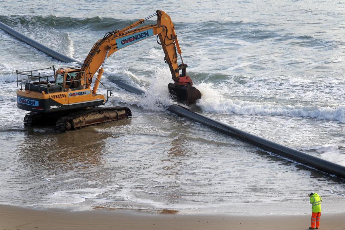 The 700m pipe used to protect Poole's beaches from coastal erosion after the winter storms is removed from Canford Cliffs. Photos by Sally Adams. 
