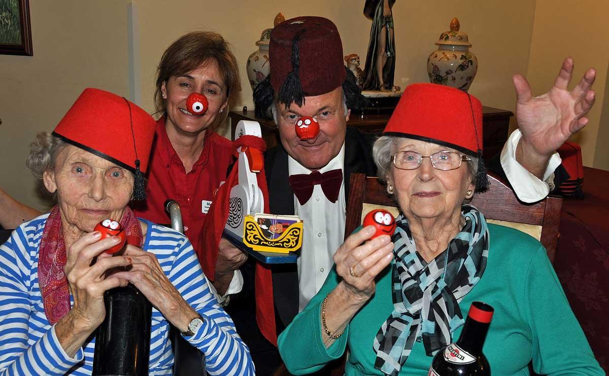 Tommy Cooper impersonator Clive Greenaway marks Comic Relief with Canford Chase Activities Organiser Maria Grant and residents Jean Palmer and Sylvia Sansome.