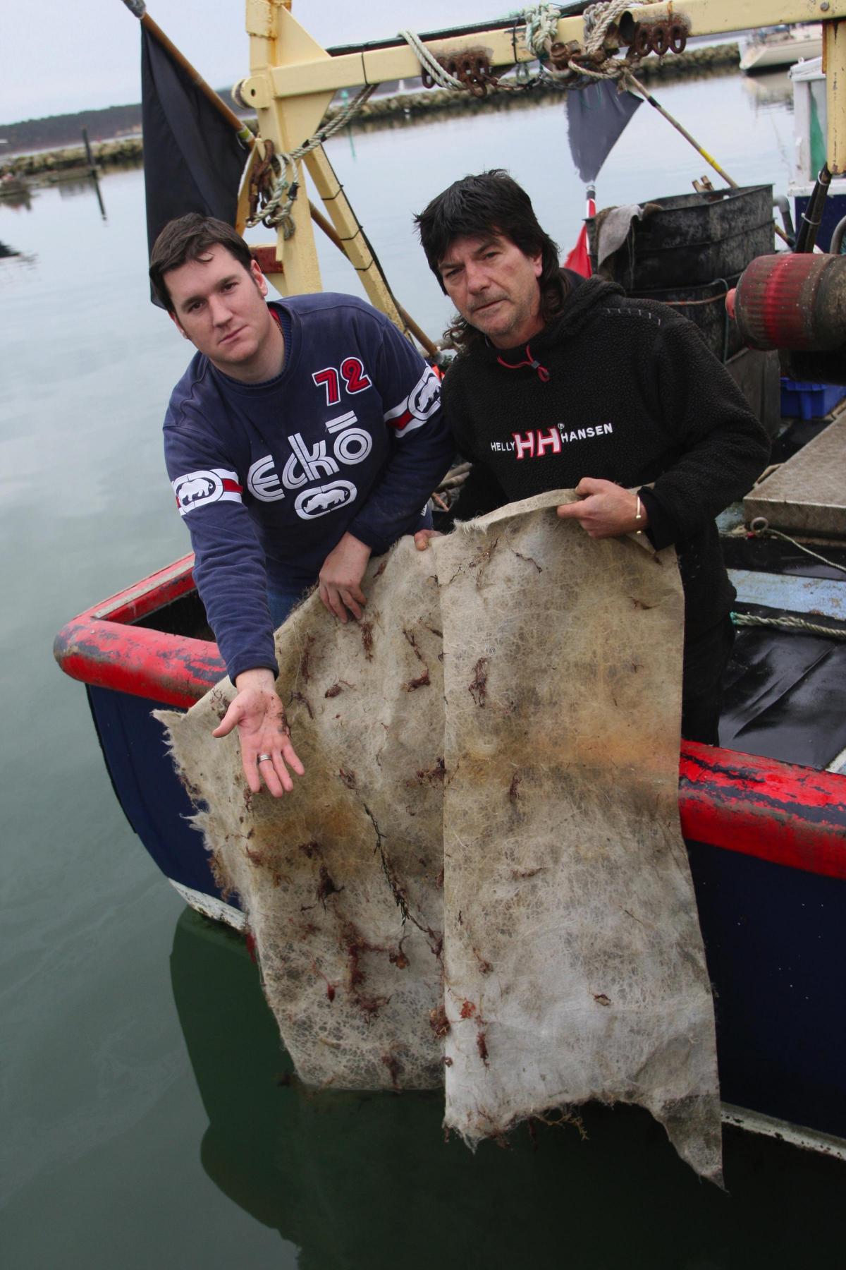 Poole fishermen Matthew Ellison and Mark Goulding with pieces of textile bagswhich got caught in the propellers of their boat in 2010