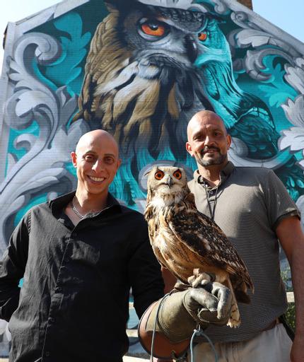 Bournemouth Echo: Artist Krishna Malla – aka Tech Moon – with Elton the owl and his handler Jason Putman of Owl Hawk Experience in front of his mural in Boscombe