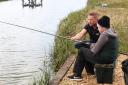 Photograph by Hattie Miles :Variety The Children's Charity fishing day with Variety Wessex committee member John Stein and professional angling coach Bob McMahon at Orchard Lakes, Bashley. John Stein is pictured helping out