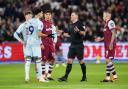 Match official Tim Robinson discusses with Dominic Solanke during the VAR check over the striker's goal at West Ham