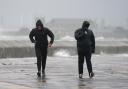 People brave the weather as they make their way along the sea front in Southsea as Storm Barra hit the UK and Ireland. Credit: PA