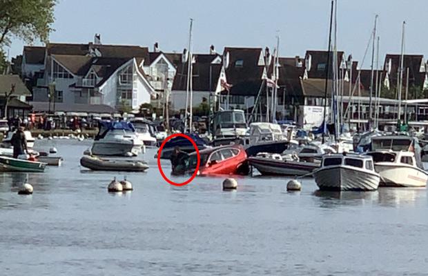 Bournemouth Echo: Image shows driver hanging out of vehicle before being rescued in Christchurch Quay