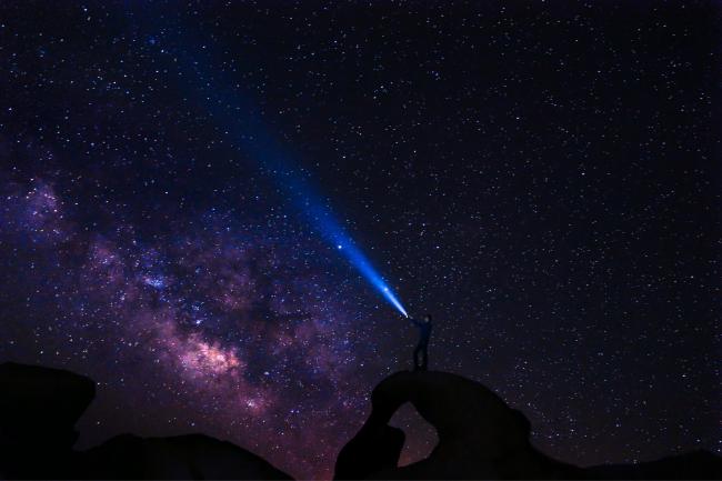 A stargazer looking out to the Milky Way. Credit: Canva