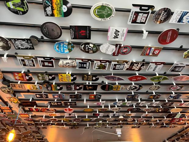 Bournemouth Echo: Beer pump clips from the past 5 years are displayed on the ceiling.
