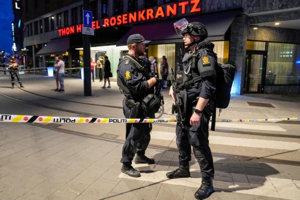 Police stand guard outside a bar in central Oslo