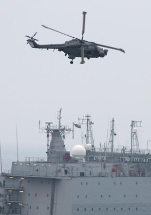 One of the Lynx helicopters from the Black Cats display team flies over the RFA Largs bay. Picture: Richard Crease.