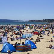 Visitors and residents soak up the sun at Bournemouth beach on June 5