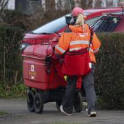 Royal Mail delivering mail (PA)