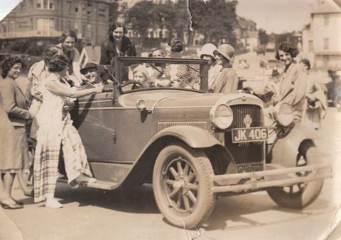 Actor Percy Marmont and a crowd of theatre girls with his car in Bournemouth, 1932.