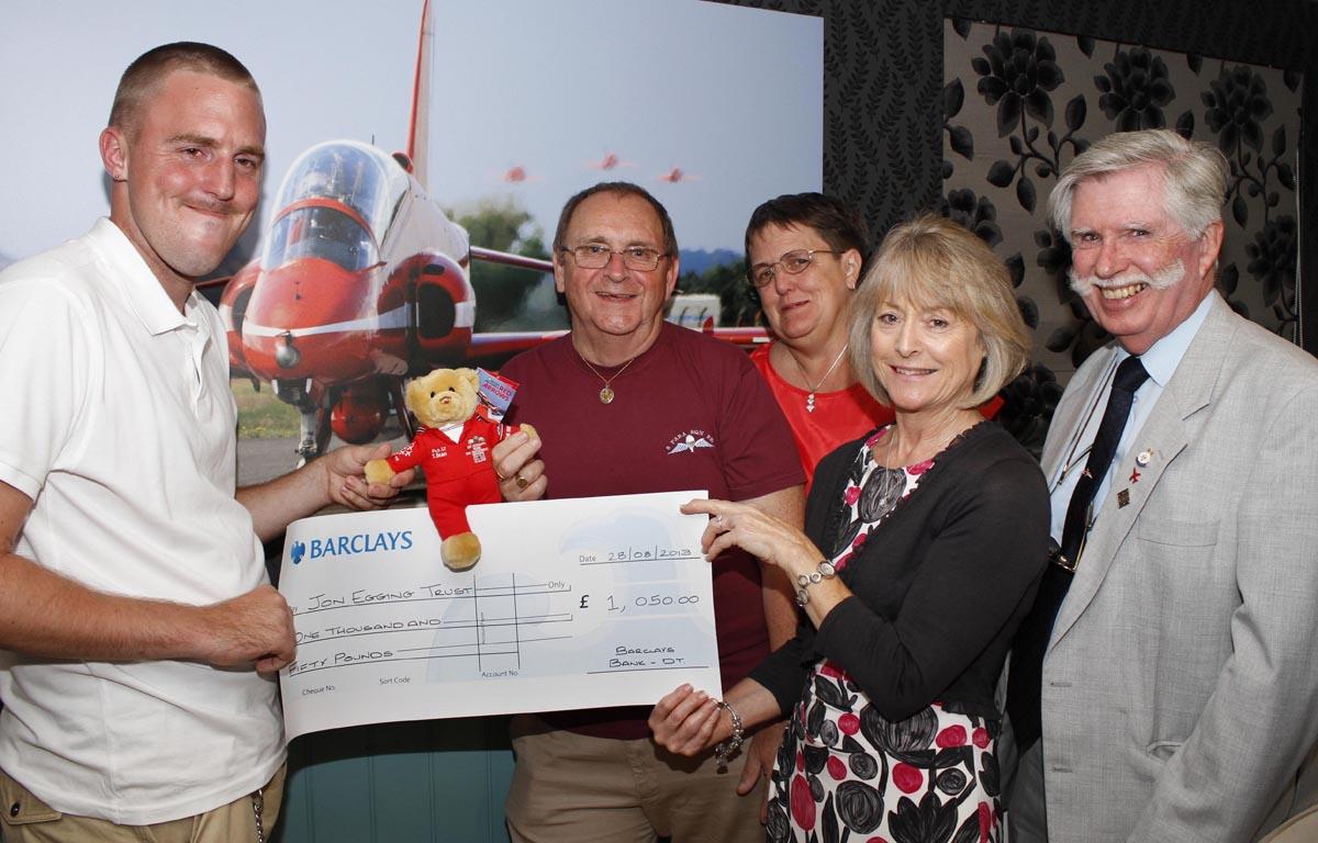 Paul Byrne with Flight Lt T Bear who parachuted into Old Sarum Aerodrome raising £1,050 for the John Egging Trust, present a cheque to Dawn Egging with Terry Trevett, right, chairman of the Bournemouth Red Arrows Association, and Aiden and Sarah Byrne.