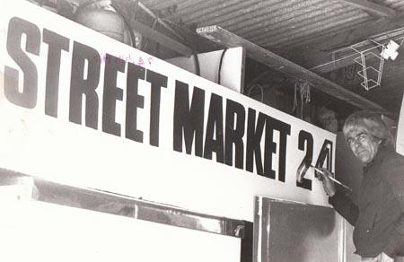 In 1978 Jonathan Hewat, one of the street market organisers puts finishing touches to the sign advertising the massive street market event celebrating Corfe Castle millenary.