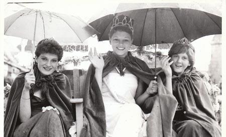 In August 1982 there were smiles and a cheery wave from Corfe Castle Carnival Queen Sarah Chaffey despite the drenching that the event received. With Sarah are her attendants Christine Bennett and Karen Baronsten.