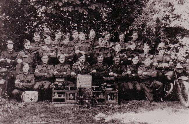 ignals Section of Wimborne Home Guard with pigeons. Pt Cecil George Ellis in the centre with Pte Rowland Lester Reginald Lawrence to the left of him in the front row, wearing glasses. Submitted by John Pidgeon. Picture belongs to the son of Pt Cecil Georg