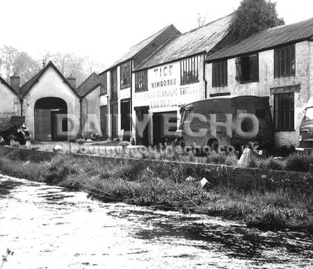 From the River Allen Tice garage and old Central garage, left, alongside East Brook Bridge in East Street, Wimborne in 1969 before the buildings were demolished to make way for a supermarket fronting East Street with shops facing onto a riverside landscap