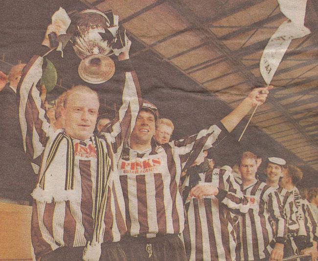 On April 25 1992 Wimborne FC won the FA Vase trophy at Wembley Stadium after beating Guiseley 5-3. Taffy Richardson hold the trophy aloft with the Magpie players behind.