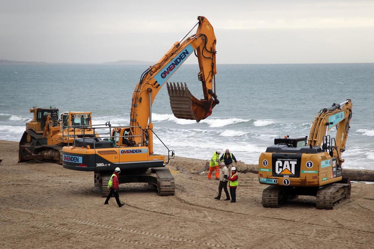 The 700m pipe used to protect Poole's beaches from coastal erosion after the winter storms is removed from Canford Cliffs. Photos by Sally Adams. 