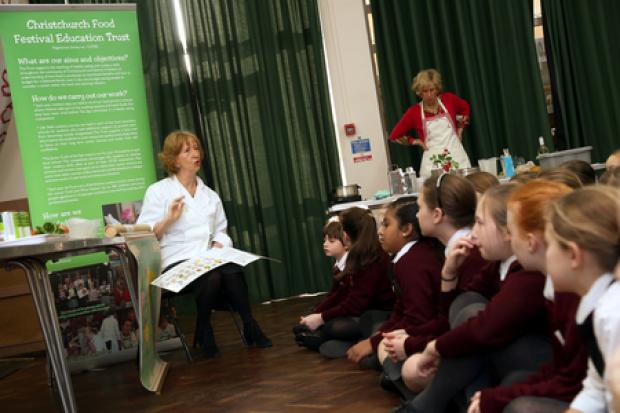Pupils at The Priory School get involved in cooking at the school as part of the Christchurch Food Festival Education Trust programme. Pictured is Mary Reader, president of the festival, with year five pupils.