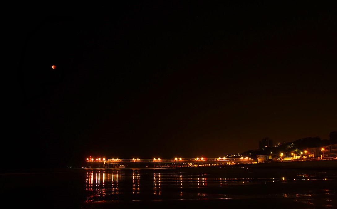 By Mark England. The Blood Moon over Boscombe Pier, at the same time as the super-low tide due to the SuperMoon