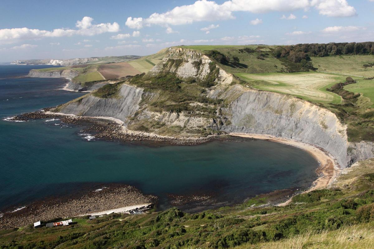 Chapmans Pool with fisherman's huts in foreground and some Jurassic coastland beyond, taken by Dave Porter.
